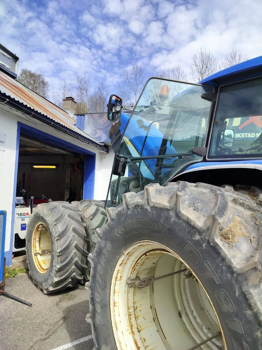 Blå traktor ved inngangen til verkstedet