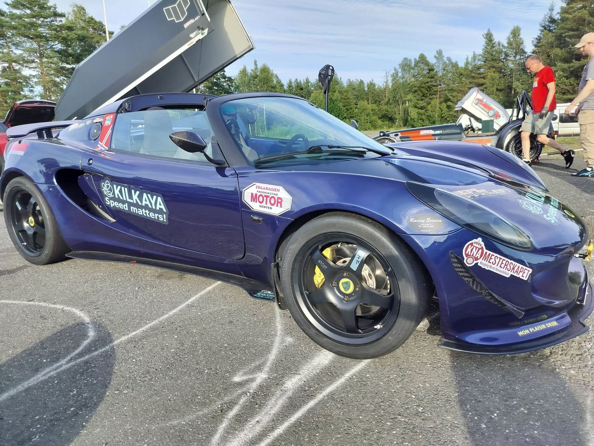 Mørkeblå Lotus Elise med Fredrikstad Motor-dekor i depotet på banen