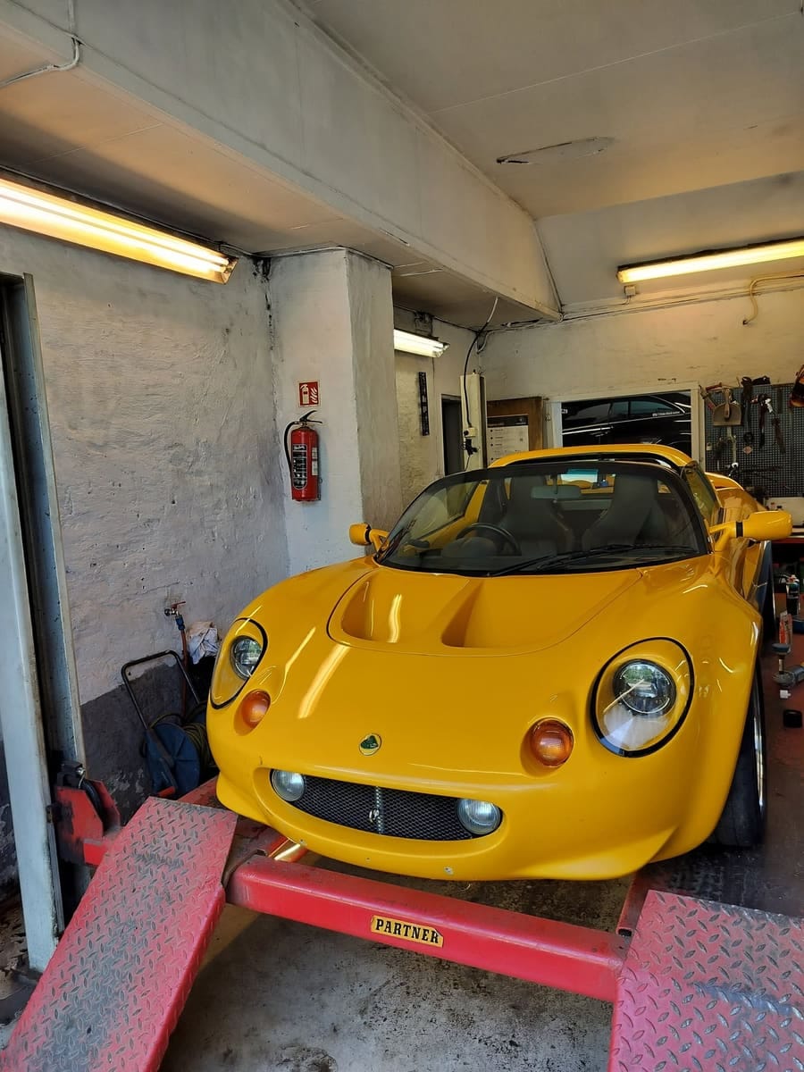 Gul Lotus Elise på rampe inne i verkstedet